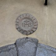 Trigramma bernardiniano sul portale bugnato di una csa del centro storico
