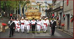 La teca viene portata in processione dai facchini in uniforme