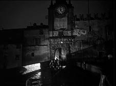 La porta dell'orologio di Capranica. Qui si raccolgono i protagonisti dopo il teatro per accogliere l'invito a cena di un notabile del paese.