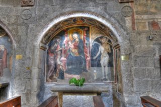 Terza cappella navata sinistra. Affresco. Sui montanti compaiono un santo non identificato ed un santo vescovo, mentre l’intradosso � trattato come quello della cappella vicina con il Cristo benedicente con ai lati i ritratti di santi e sante, sempre inscritti in clipei dipinti. L’affresco venuto alla luce durante i lavori di restauro del 1907/11 � stato attribuito da Faldi al Balletta. 