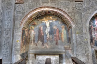  Crocifissione con S. Giovanni Battista, la Vergine, s. Giovanni Evangelista, S. Giacomo Maggiore e la Maddalena; sui montanti compaiono due scene con apparizioni di angeli a due santi, mentre nell’intradosso dell’arco sono dipinti entro clipei circoscritti da cornici a finte tarsie marmoree il Cristo benedicente con ai lati i ritratti di santi e sante. Il dipinto datato alla prima met� del Trecento si presenta di qualit� molto sostenuta e risente di palesi influenze delle pi� alte manifestazioni artistiche senesi afferenti ai modi di Simone Martini e dei Lorenzetti,