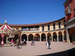 L'elegante plaza dell'outlet di Valdichiana con giostrina per bambini