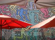 Il murale fa da coloratissimo sfondo ai tavolini di un bar