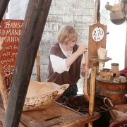 Un ragazzo in costume tipico prepara il croccante per i turisti che affollano il centro storico